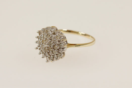 A 9ct gold diamond cluster ring with a high basket setting, showing a dome-shaped design with multiple diamonds arranged closely together. UK finger size L.