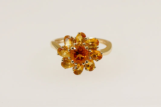 A 9ct gold ring with a flower design, featuring teardrop and round citrines.