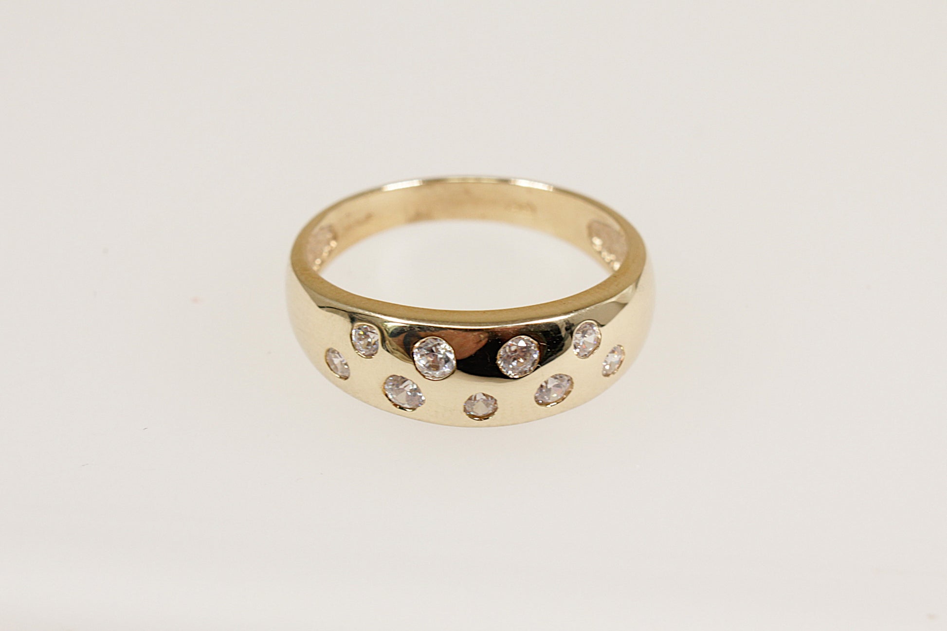 A 9ct yellow gold ring with a series of round-cut white crystals set in two staggered rows on the top.