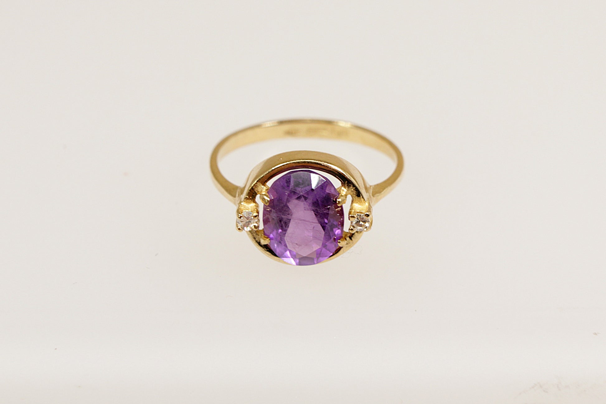 An 18ct yellow gold amethyst solitaire ring  the Amethyst is flanked a round cut diamond on each side, the ring is stamped 750 for 18ct gold, UK finger size  L.