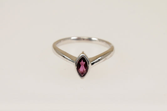 A marquise cut garnet ring with a bezel setting, in silver color, with a white background.