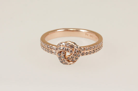 A Pandora Silver Gilt ring with a knot design, featuring Cubic Zirconia stones set in the knot and on the shoulders, displayed against a white background.