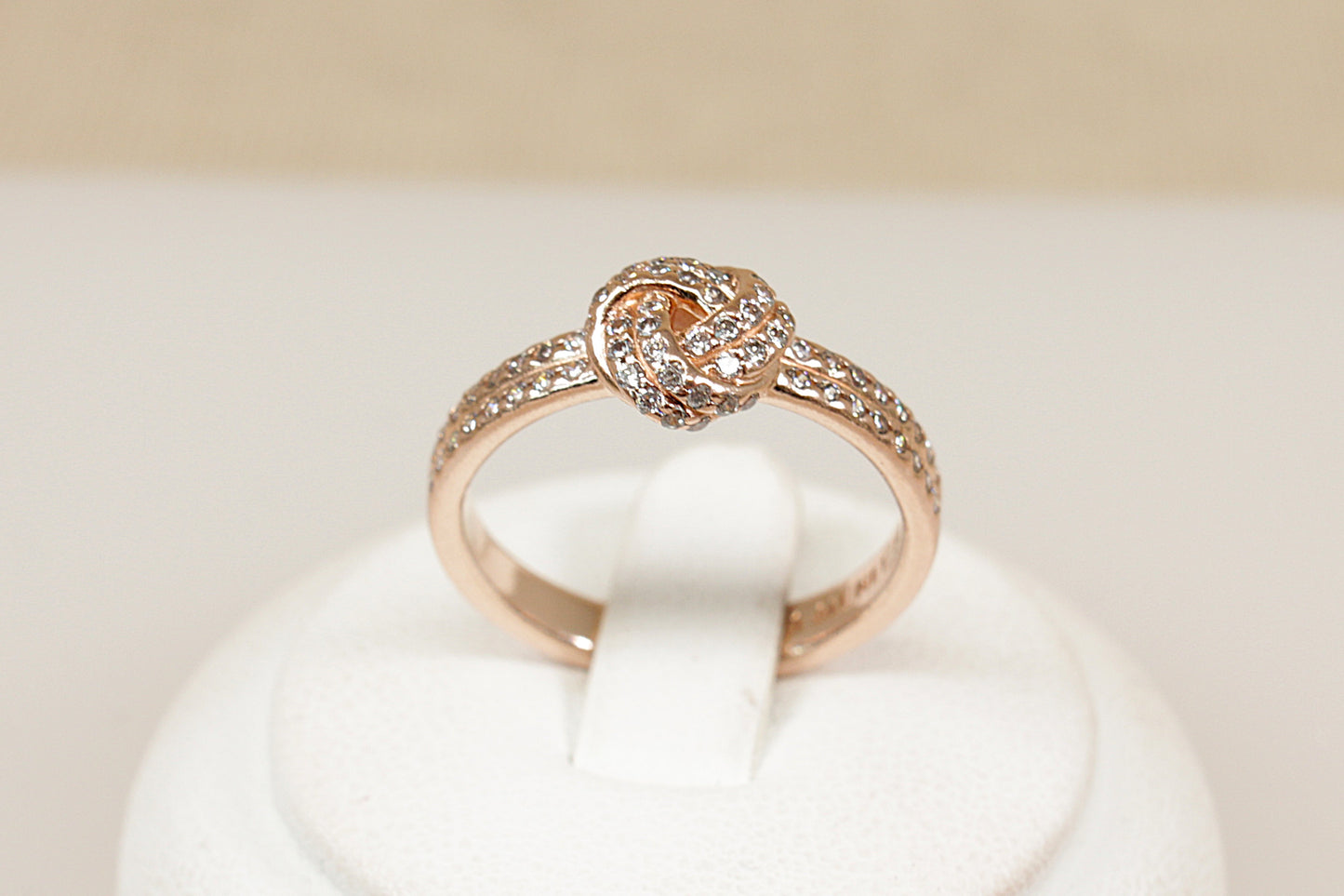 Silver gilt pandora ring sitting on a white display stand