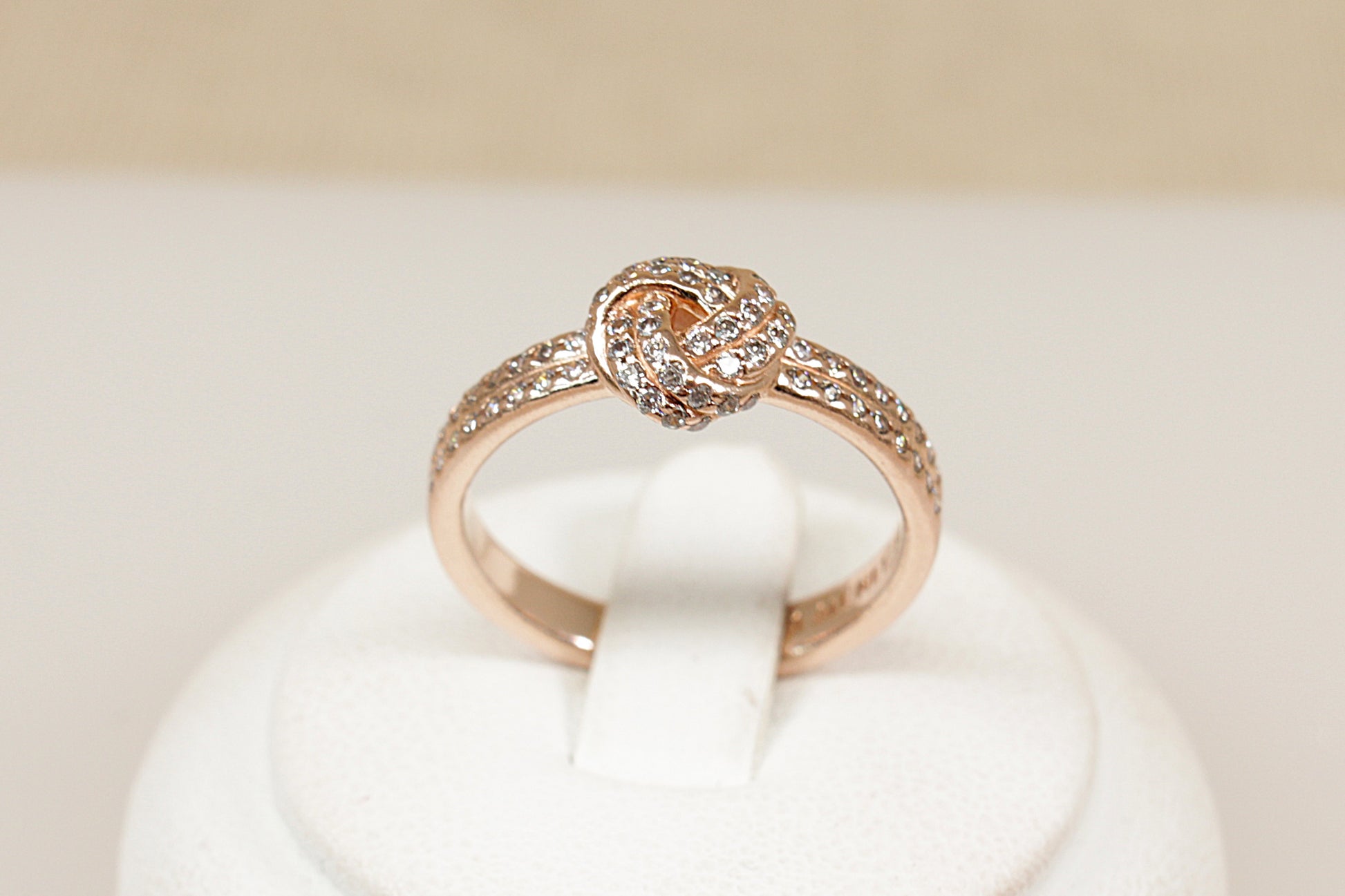 Silver gilt pandora ring sitting on a white display stand