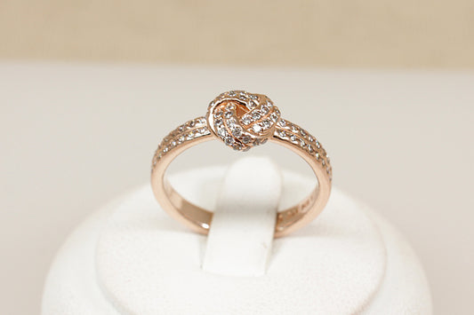 Silver gilt pandora ring sitting on a white display stand