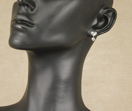 These stylish Silver earrings are in the shape of a heart with a stud fastening, a further smaller heart dangles, catching the light, from the bottom of the larger heart.