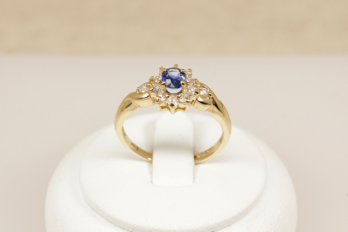 A timeless and elegant 9ct gold ring, inspired by the iconic Diana style. At its centre sits a rich oval sapphire, surrounded by a halo of 10 sparkling diamonds, creating a classic and regal look in a more delicate, wearable size, UK finger size P.