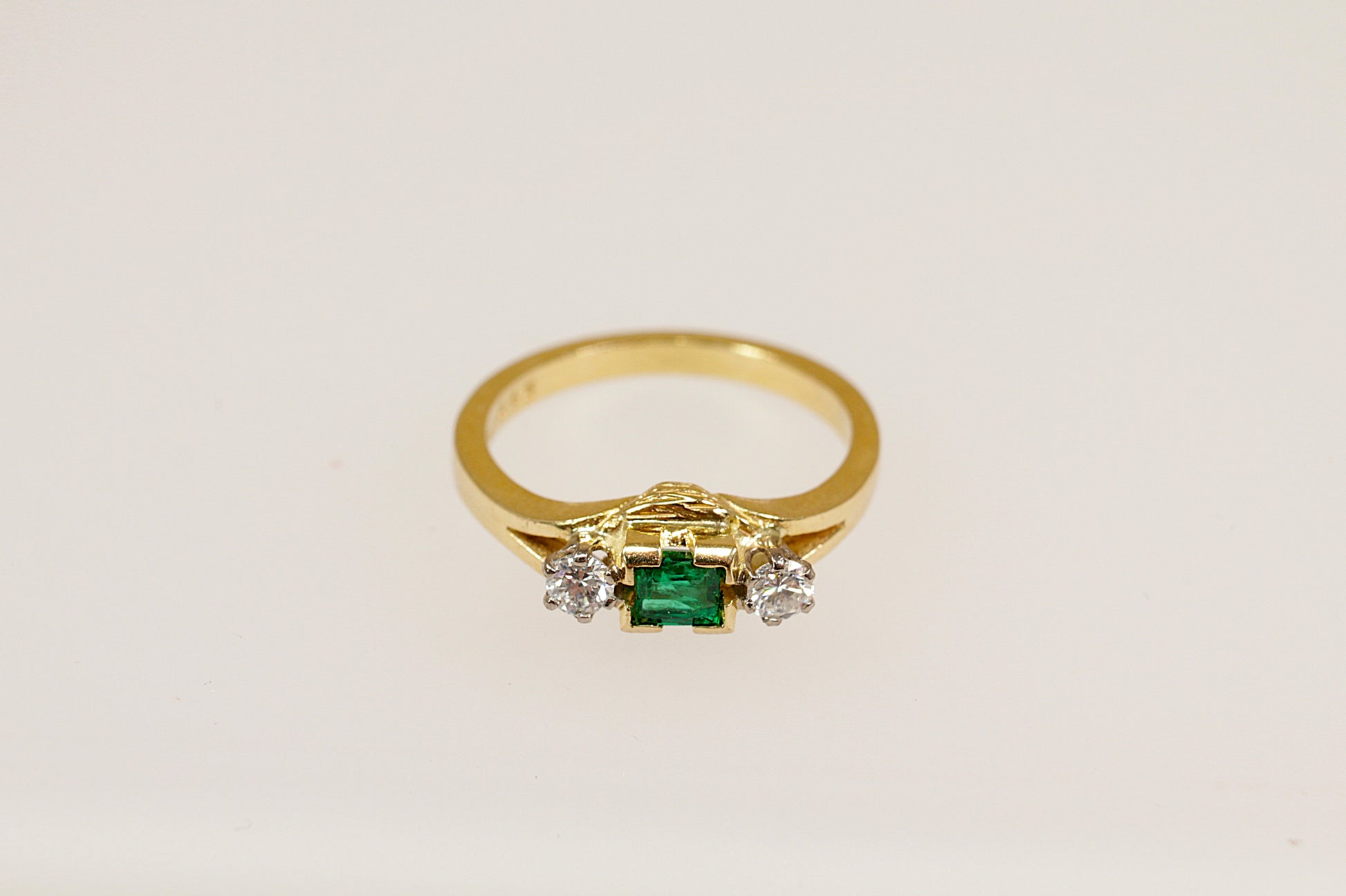 18ct yellow gold emerald and diamond trilogy ring.