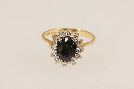 18ct yellow gold sapphire and diamond ring in the classic 'princess diana' style this beautiful ring has a 1.25 carat (estimated) blue sapphire surrounded with a halo of 12 sparkling round cut diamonds UK finger size N. 