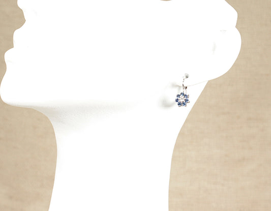 A pair of 18ct white gold sapphire and diamond earrings displayed on a mannequin head.