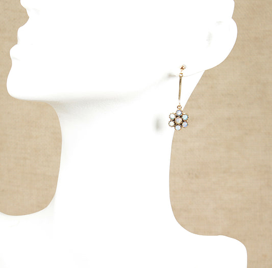A pair of vintage 9ct gold and blue moonstone drop earrings, displayed against a silhouette background.