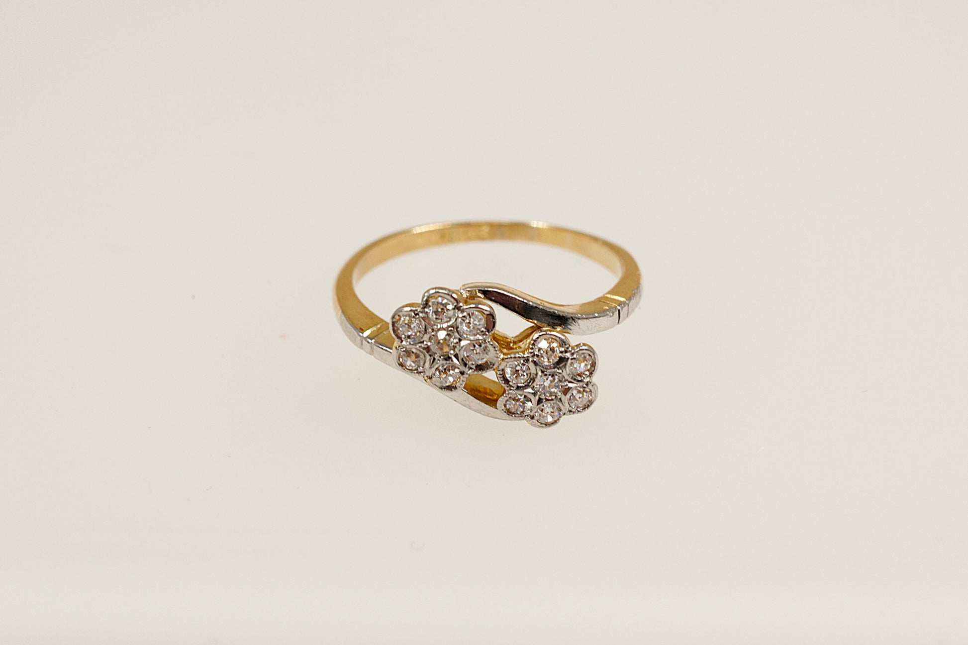 A vintage 18ct gold diamond cluster ring with a duo of daisy flower heads design, featuring multiple diamonds.