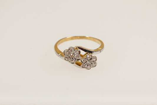 A vintage 18ct gold diamond cluster ring with a duo of daisy flower heads design, featuring multiple diamonds.