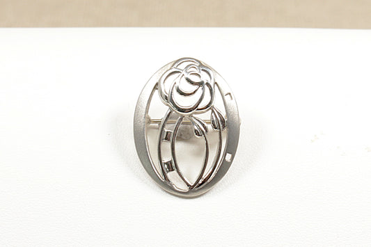 This is a beautiful, handcrafted Silver brooch by the renowned designer Kit Heath. Their designs are often inspired by nature and classic movements like Art Nouveau and this brooch has this with its graceful flowing vines and nature inspired motifs. It is in excellent condition and stamped KH and 925 for sterling silver.