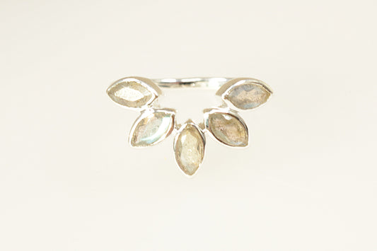 This Silver designer ring has a stunning and unique design. Handcrafted by the designers at POM 925, it has 5 marquis cut Labradorite gems, bezel set, that’s arranged in a half-halo flower pattern. 
The marquis cut stones emphasise the natural flash of labradorescence and the bezel settings provide both security and a sleek modern look. It is stamped 925 inside the band for sterling silver. UK finger size P.