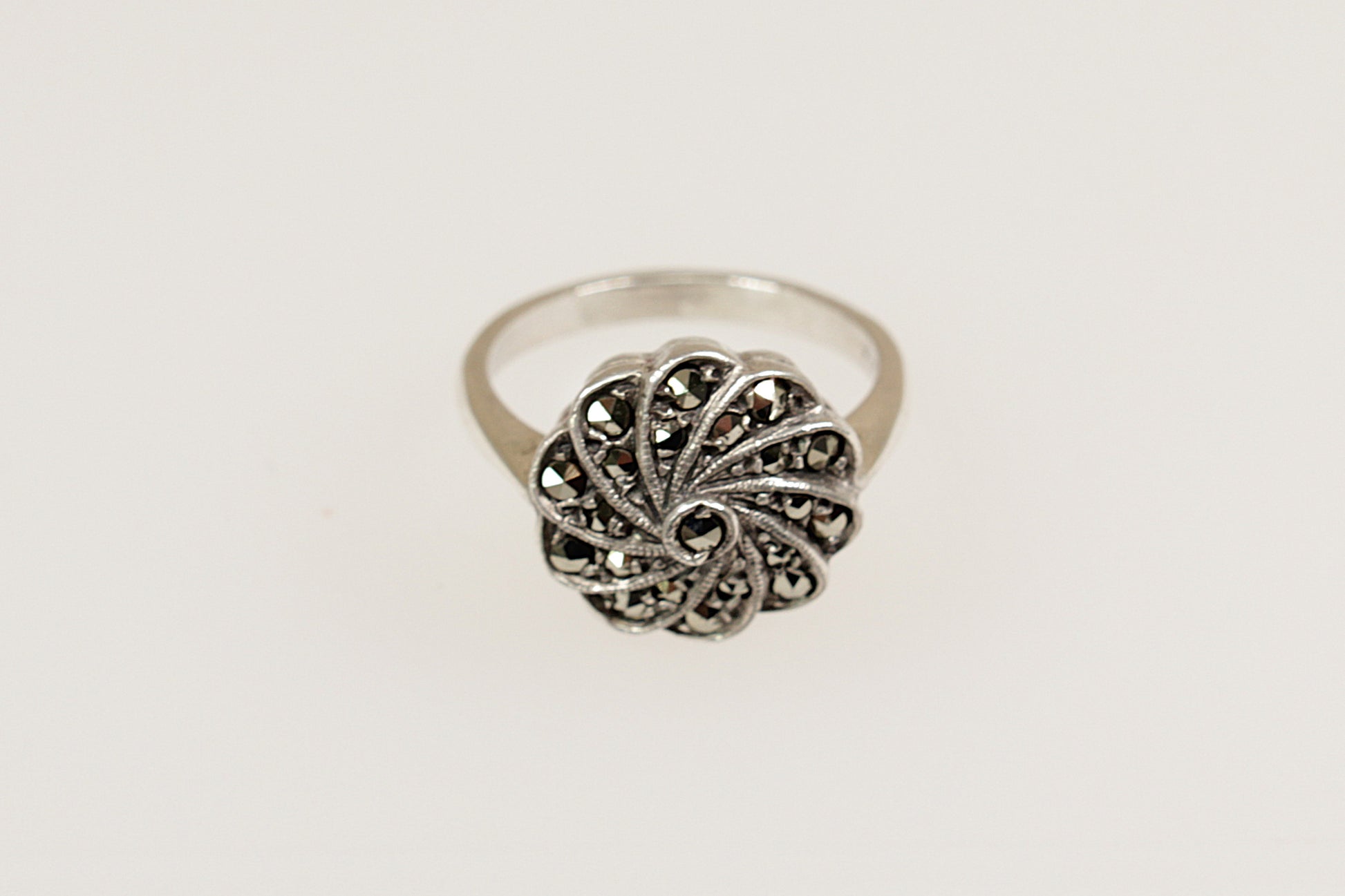 An Art Deco silver ring with a floral design, featuring marcasite stones.
