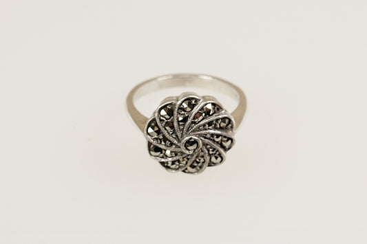 An Art Deco silver ring with a floral design, featuring marcasite stones.