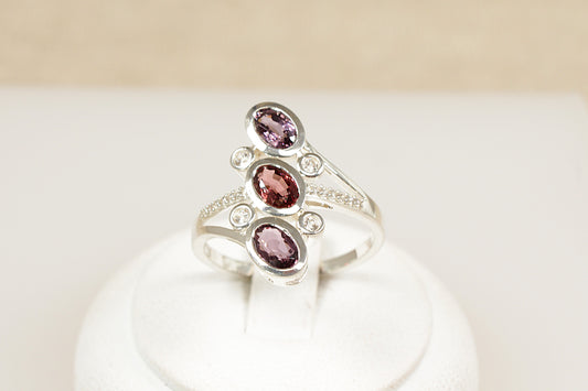 A sterling silver statement ring with three oval-cut multi-colour Spinel gemstones, accompanied by sparkling white spinel stones set in a twisted band.