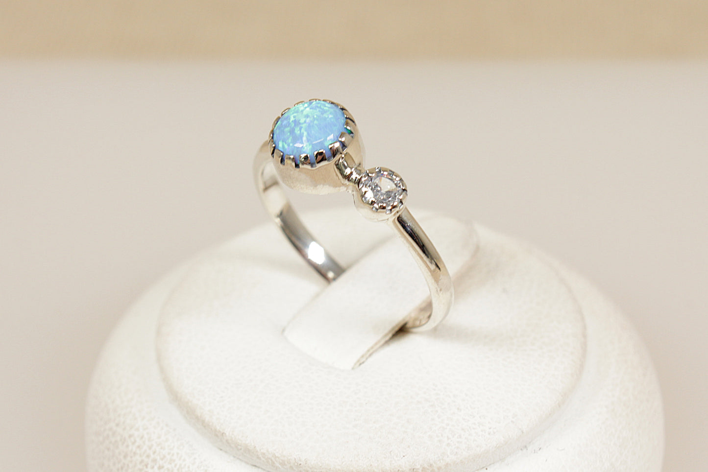 Silver ring with a blue opal gemstone on a white background