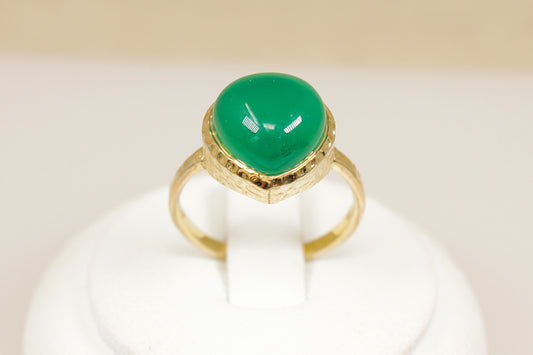 Silver gilt ring with a green gemstone on a white background