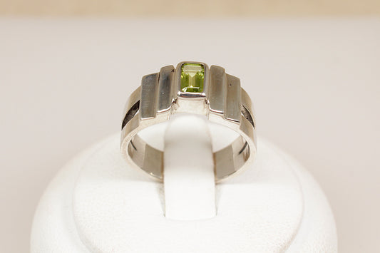 Silver ring with a green gemstone on a white background