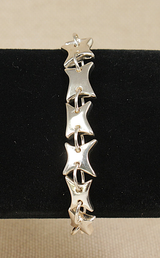 Silver star-shaped bracelet on a black and beige background