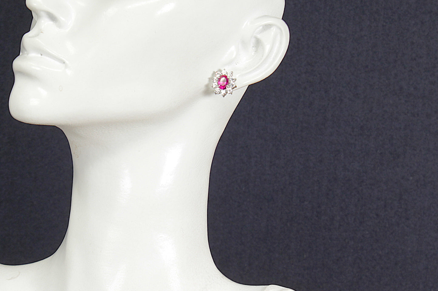 Ruby earring on a mannequin ear with a dark background