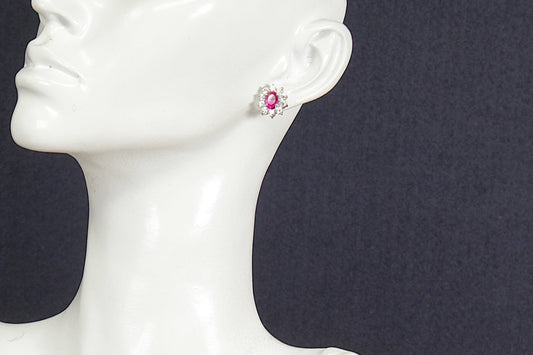 Ruby earring on a mannequin ear with a dark background