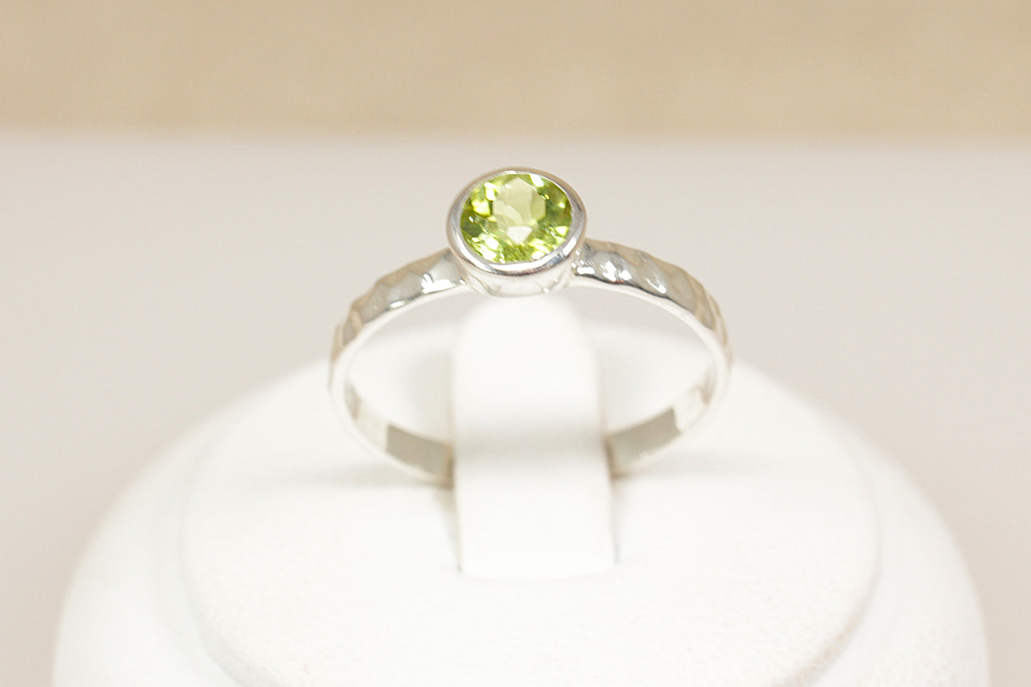 Silver ring with a green gemstone on a white background