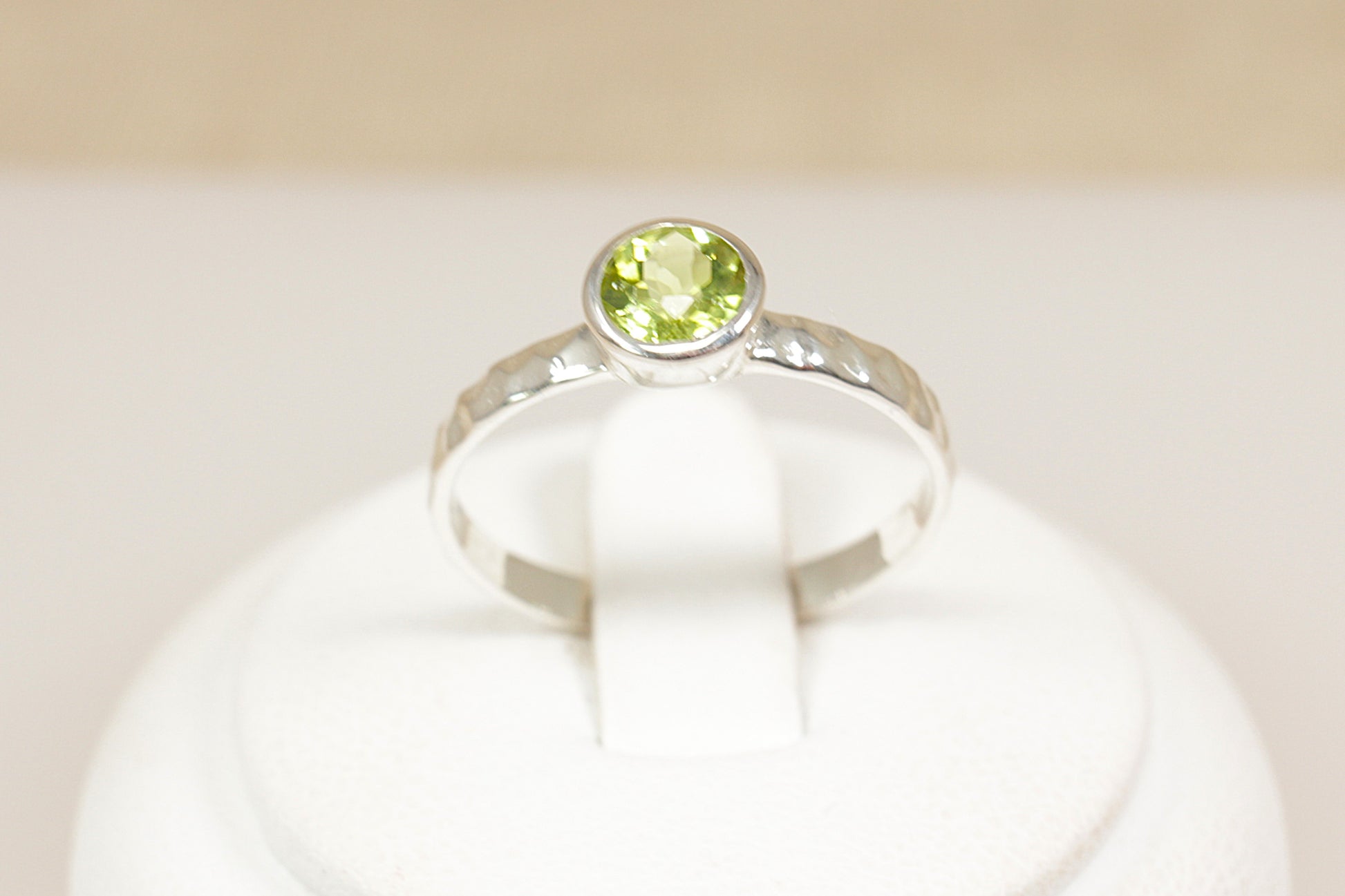 Silver ring with a green gemstone on a white background