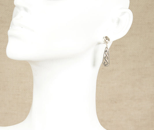 Silver earring on a beige background