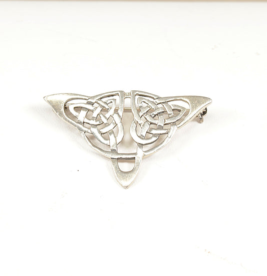 Silver Celtic knot brooch on a white background