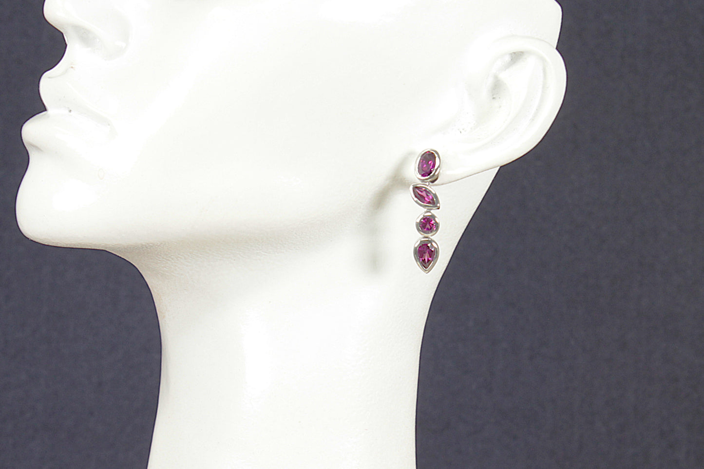 Silver Amethyst Drop Earrings on a mannequin ear with a dark background