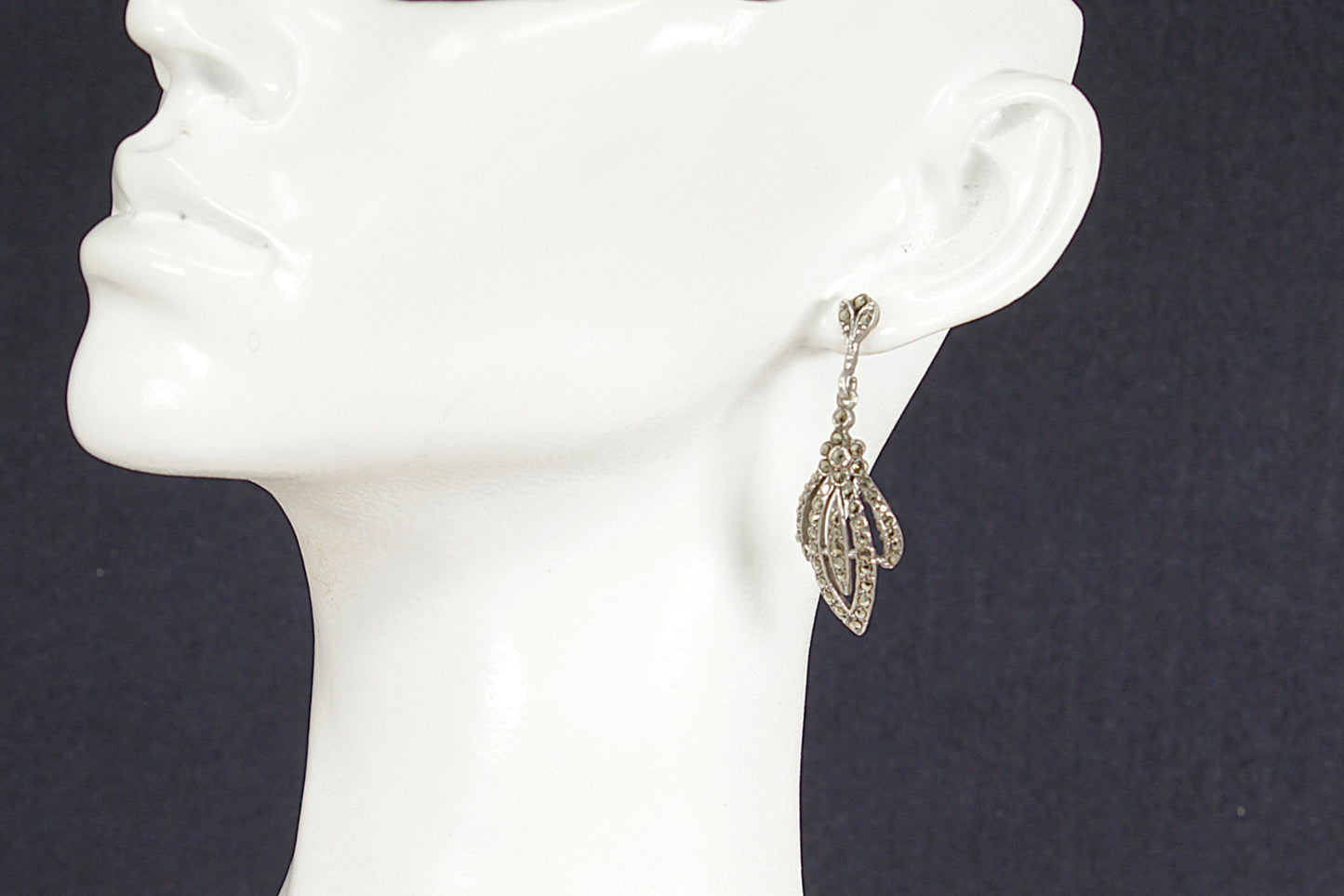 Art Deco Silver Marcasite Earring on a mannequin ear against a dark background