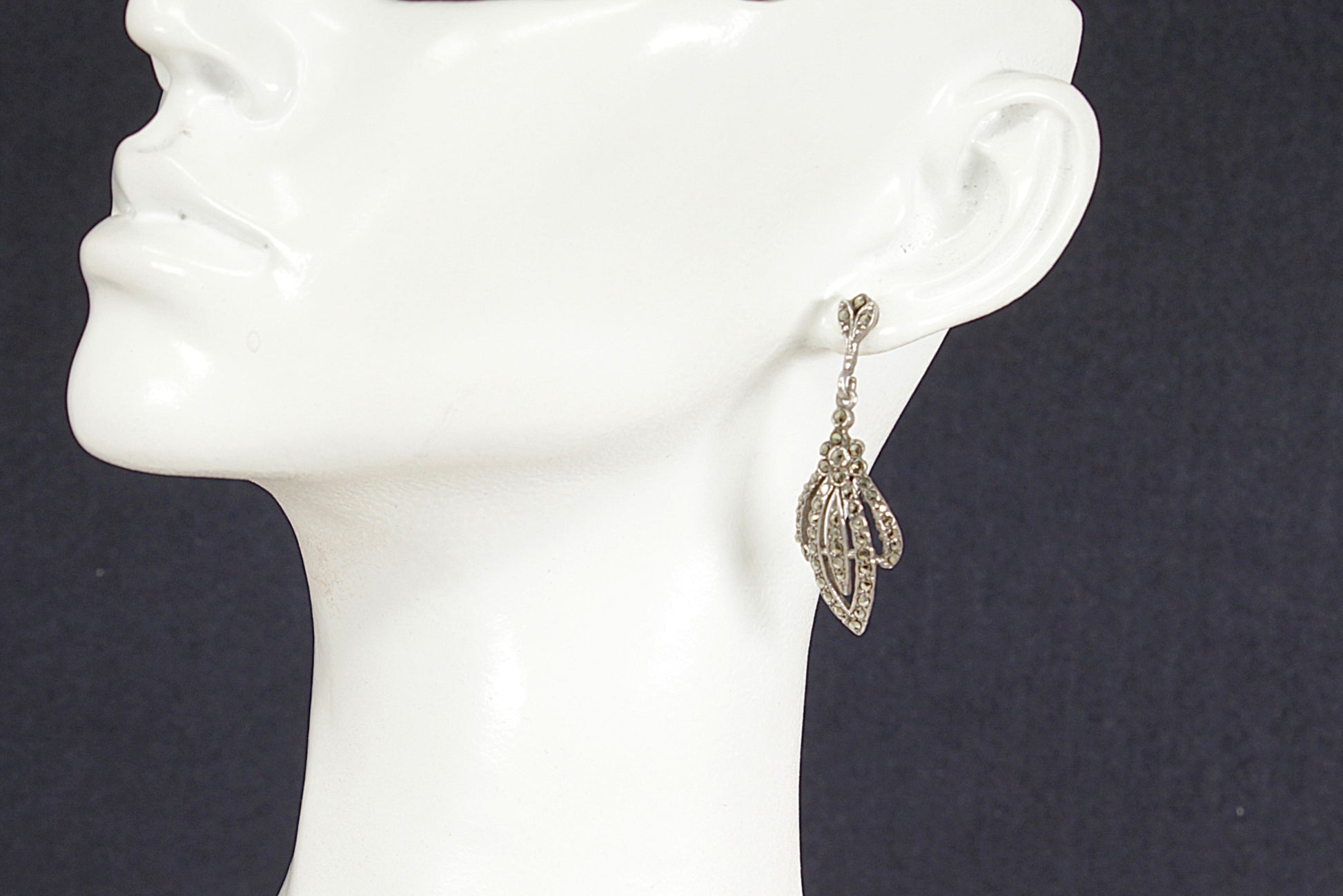 Art Deco Silver Marcasite Earring on a mannequin ear against a dark background