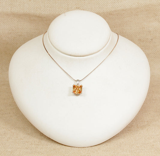 Necklace with a square pendant on a white mannequin bust against a beige background