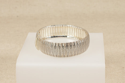 Italian sterling Silver flexi bracelet on a white stand against a beige background