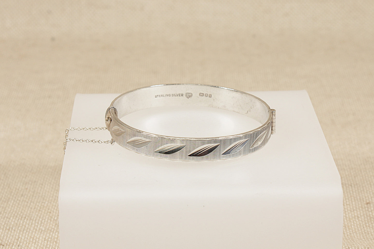 Vintage Antique Silver bracelet hinged bangle on a white box with a beige background