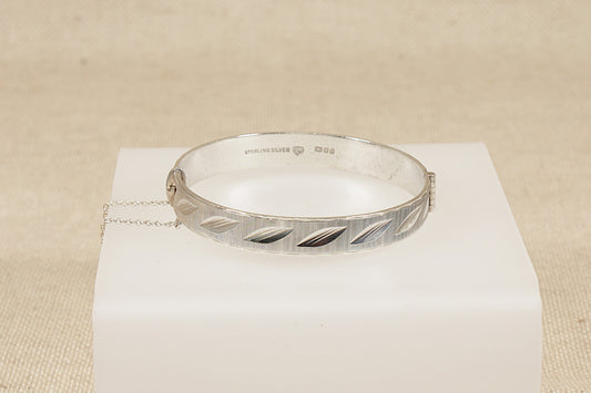 Vintage Antique Silver bracelet hinged bangle on a white box with a beige background