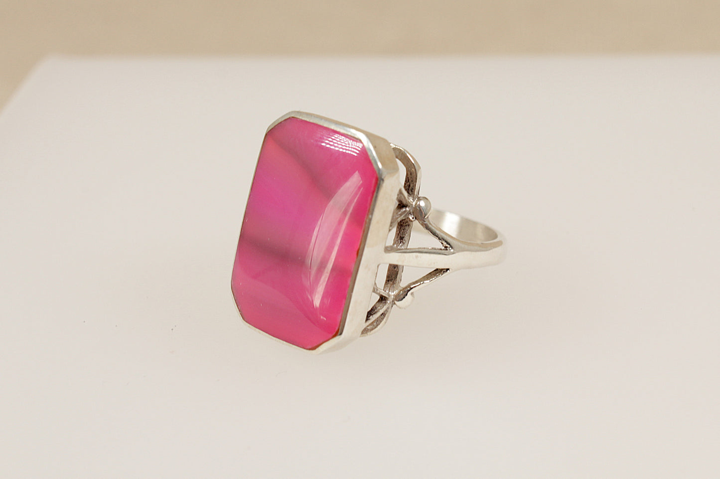 Silver ring with a pink stone on a white background
