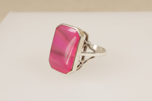 Silver ring with a pink stone on a white background