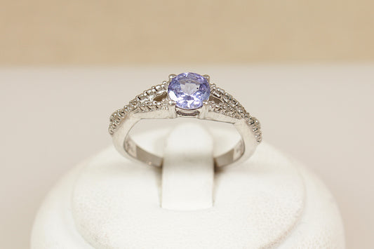 Silver solitaire ring with a blue iolite gemstone on a white cushion