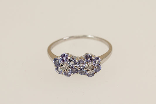 Silver ring with blue iolite and diamond   gemstones on a beige background
