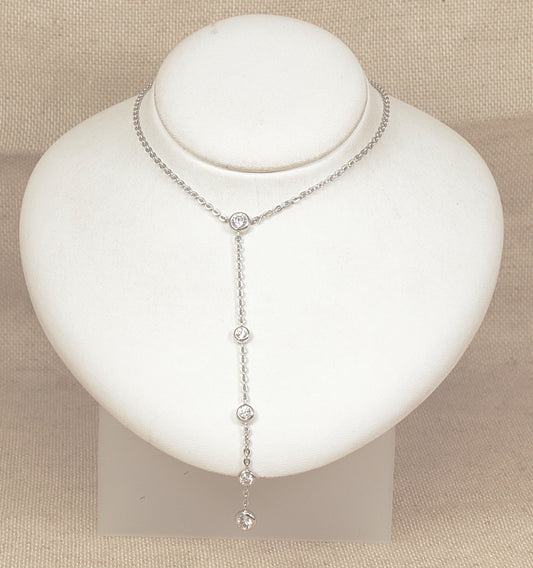 Silver necklace with small cz diamond simulant gemstones on a white mannequin bust against a beige background