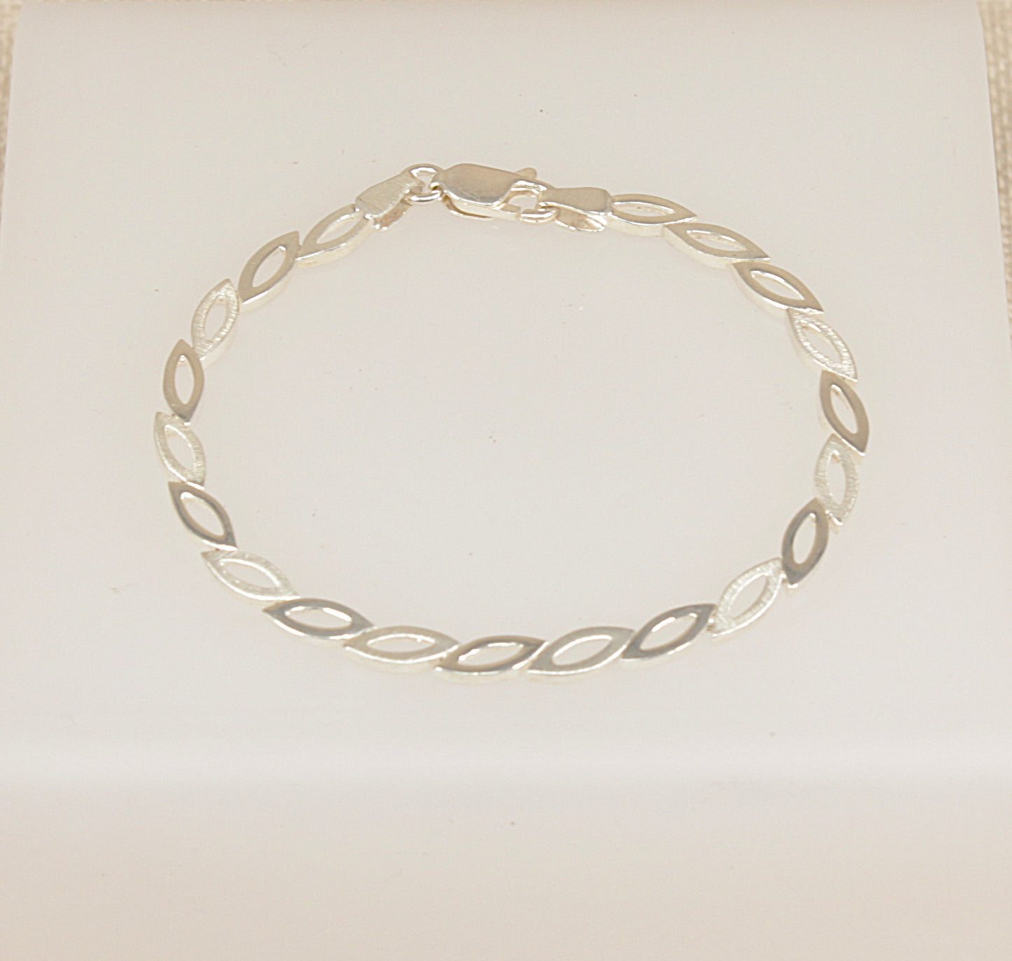 Silver bracelet on a light beige background