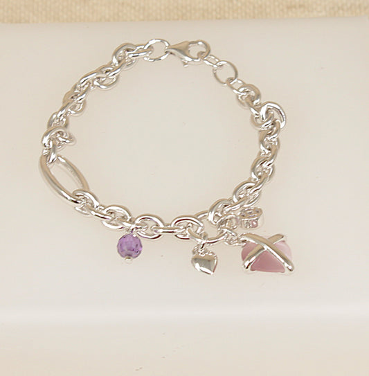 Silver bracelet with charms on a light beige background