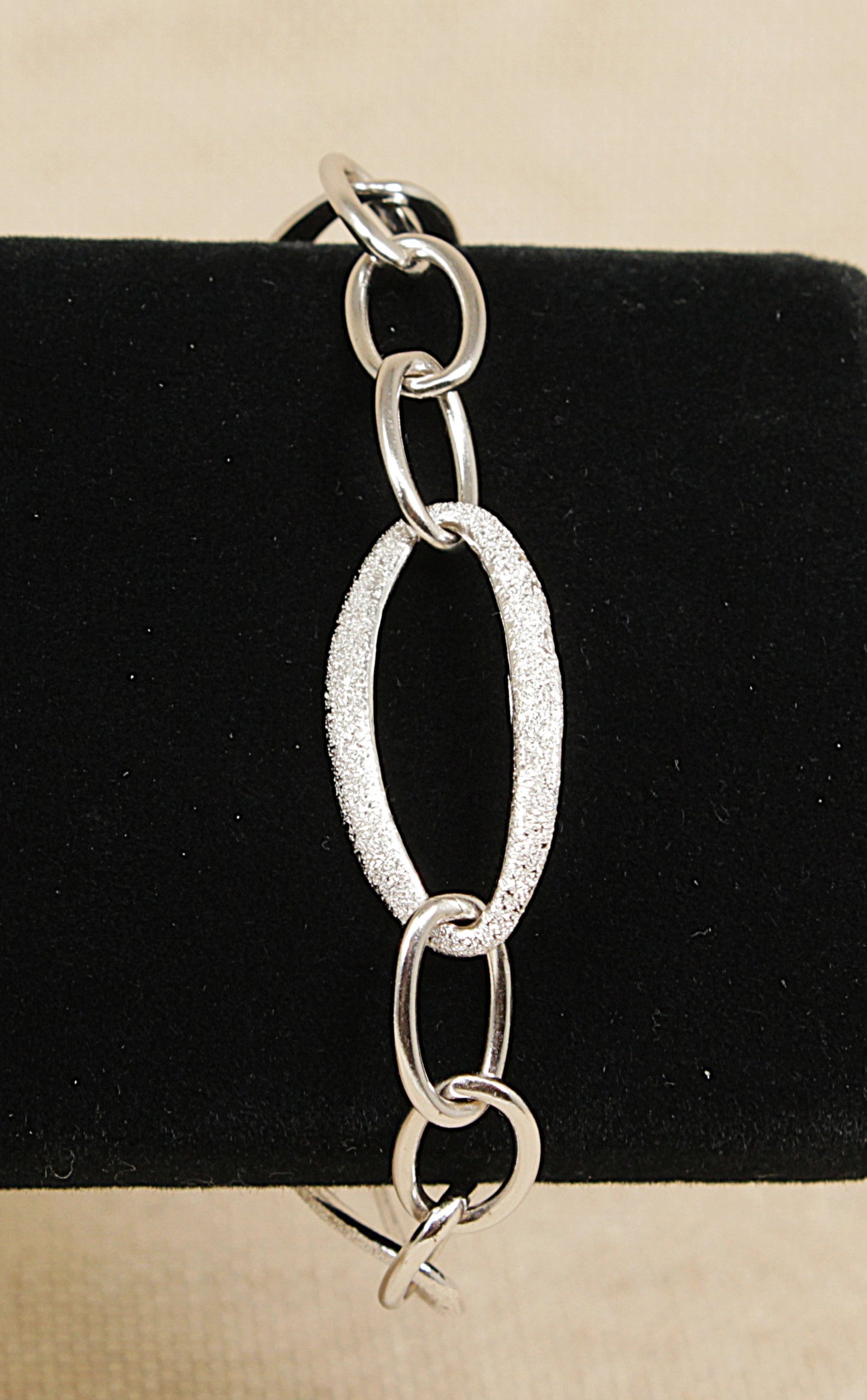 Silver chain bracelet on a black and beige background