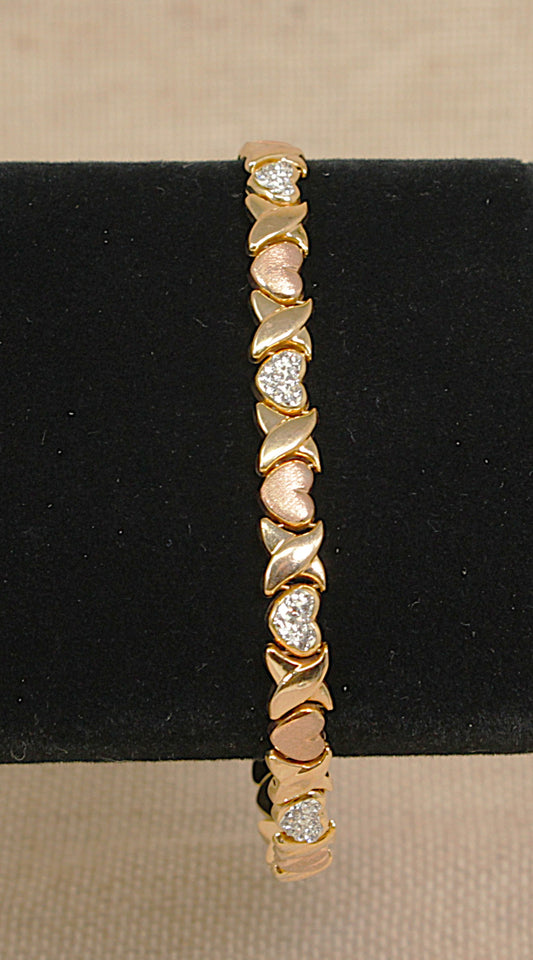 Silver gold plated bracelet with heart-shaped crystals on a black stand