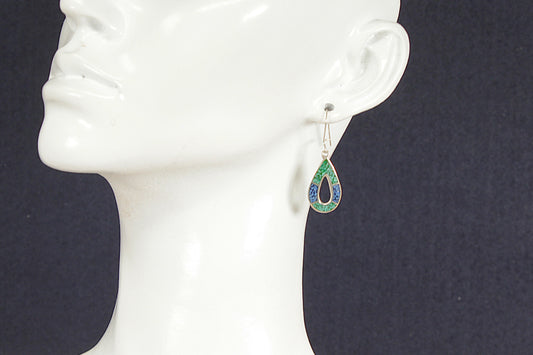 Teardrop-shaped earrings on a mannequin head against a dark background