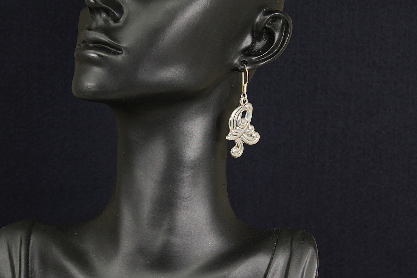 Earring on a mannequin against a dark background